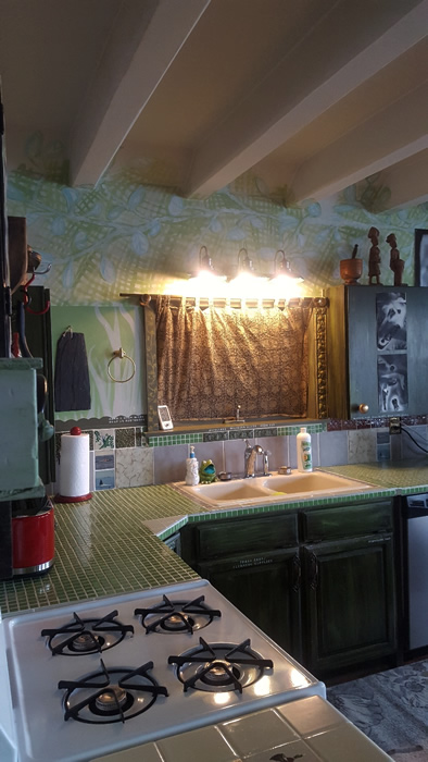 Green vintage tile countertops in kitchen with a deep porcelain sink.